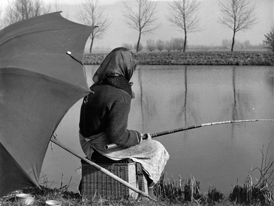 361074 Afbeelding van een vissende vrouw, vermoedelijk aan het Amsterdam-Rijnkanaal.